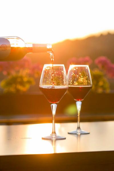 Si versa il rosso in due bicchieri al tramonto
