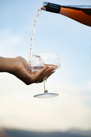 Si versano le bollicine in una coppa, contro il cielo