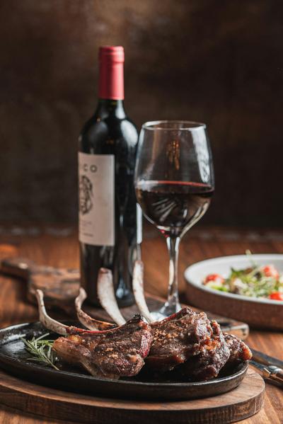Costolette d'agnello con vino rosso e insalata